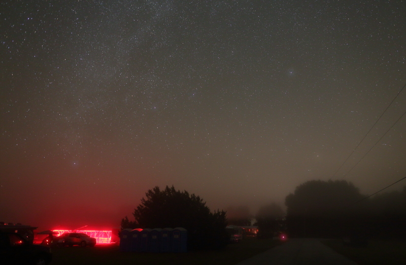 The red lights under the shelter roof create a red glow in the fog